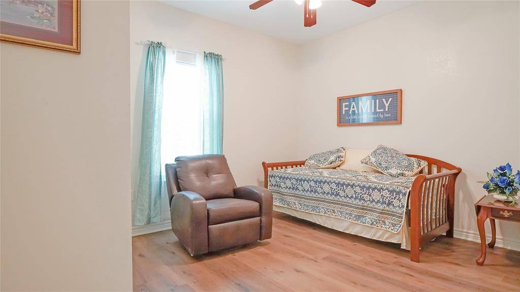 Just off of the living room lies the secondary bedroom which is well lit by natural light through a large window.