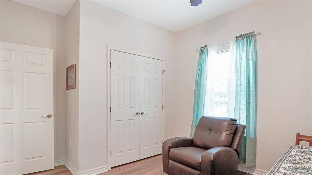 Just off of the living room lies the secondary bedroom which is well lit by natural light through a large window.