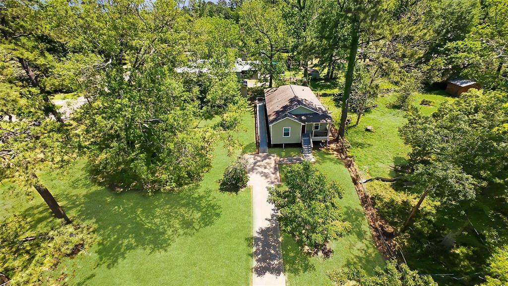This aerial view showcases peaceful country living—spacious front yard, mature trees, and endless potential for outdoor living or expansion. A true private retreat with wide-open skies.