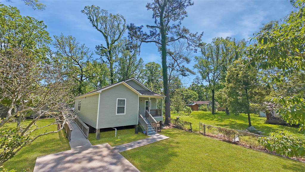 From the front side, the home’s classic charm shines with a spacious front porch, mature trees, and a wide front yard. A thoughtfully accessible wheelchair ramp provides easy access, blending functionality with the home's welcoming design—perfect for all stages of life.