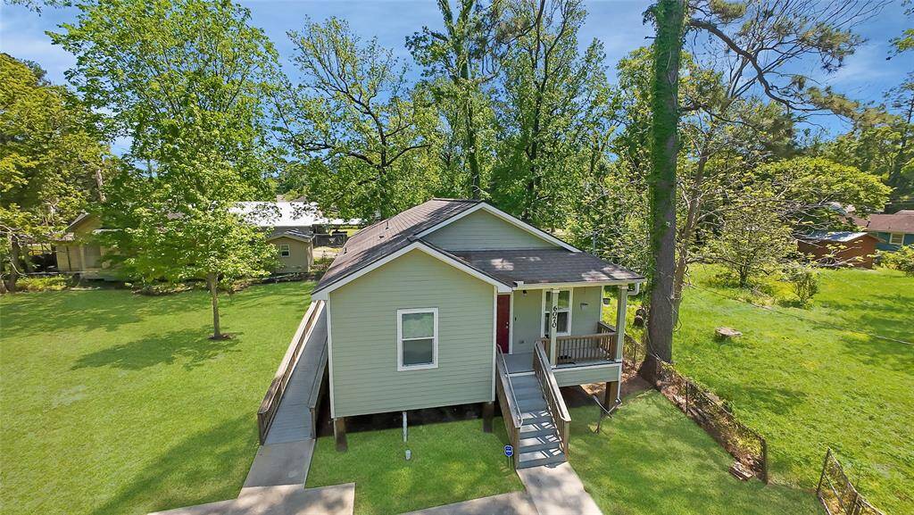 From the front side, the home’s classic charm shines with a spacious front porch, mature trees, and a wide front yard. A thoughtfully accessible wheelchair ramp provides easy access, blending functionality with the home's welcoming design—perfect for all stages of life.