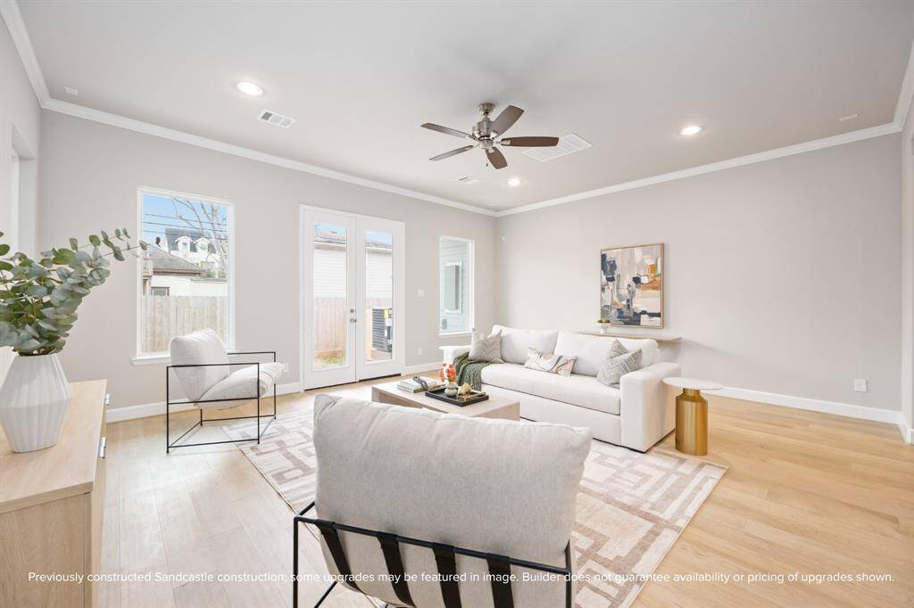 Light, air, and warmth fill the living room, with French doors opening to a fenced backyard—finishes in the completed home were curated by LYRD Interiors.