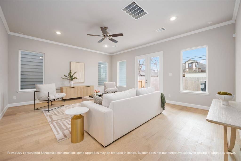 Generous windows and French doors frame the living area with light and backyard views—construction is underway, with move-in expected July 2025.