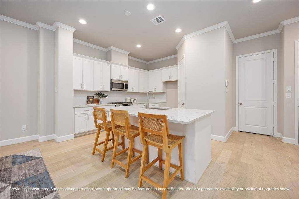 The oversized island is made for morning coffee, late-night snacks, and everything in between—surrounded by custom soft-close cabinets, quartz countertops, and finishes curated by ASID award-winning LYRD Interiors. Final selections may vary.