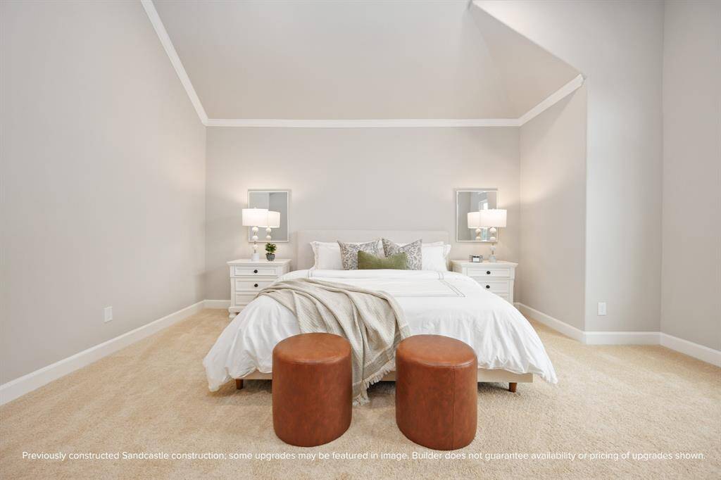 Neutral tones, classic trim, and symmetry create a sense of ease and timeless style in the generously sized primary bedroom.