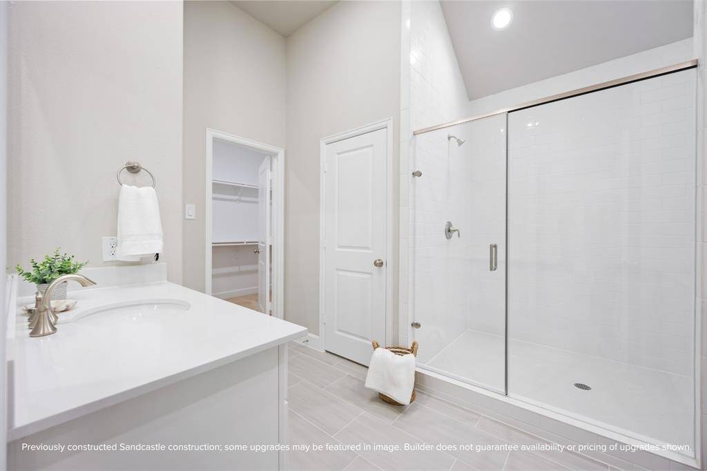 The spa-inspired primary bath features a frameless glass shower with dual showerheads for a truly luxurious experience.