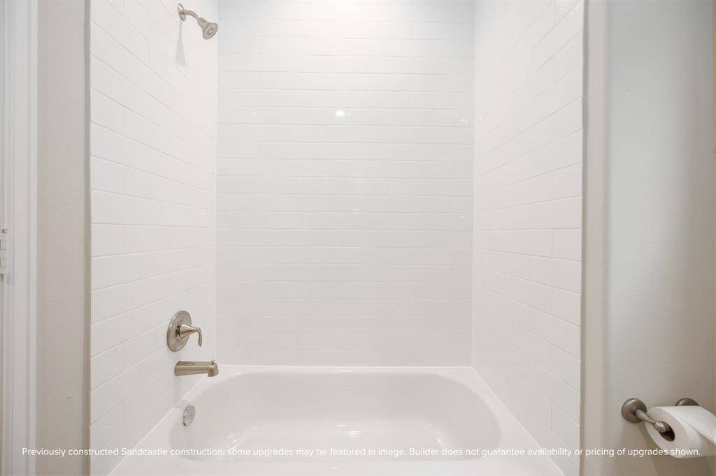 A timeless combo of white subway tile and polished hardware makes the tub/shower feel fresh and functional for guests or kids