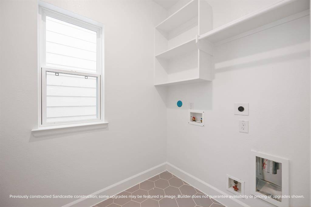 With full-size washer/dryer hookups, upper cabinets, and natural light, this utility room makes laundry day a little brighter.