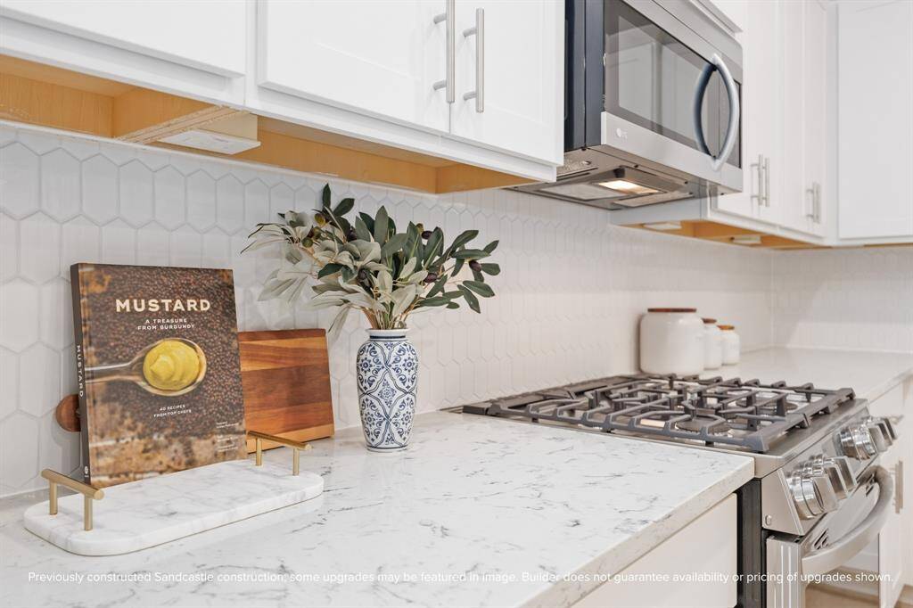 With elegant tilework, quartz counters, and a gas cooktop ready for your signature dish, this kitchen blends utility with warmth—final selections by LYRD Interiors may vary.