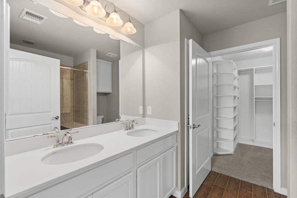 The primary bath offers dual sinks for added convenience and a spacious California closet for organized storage.