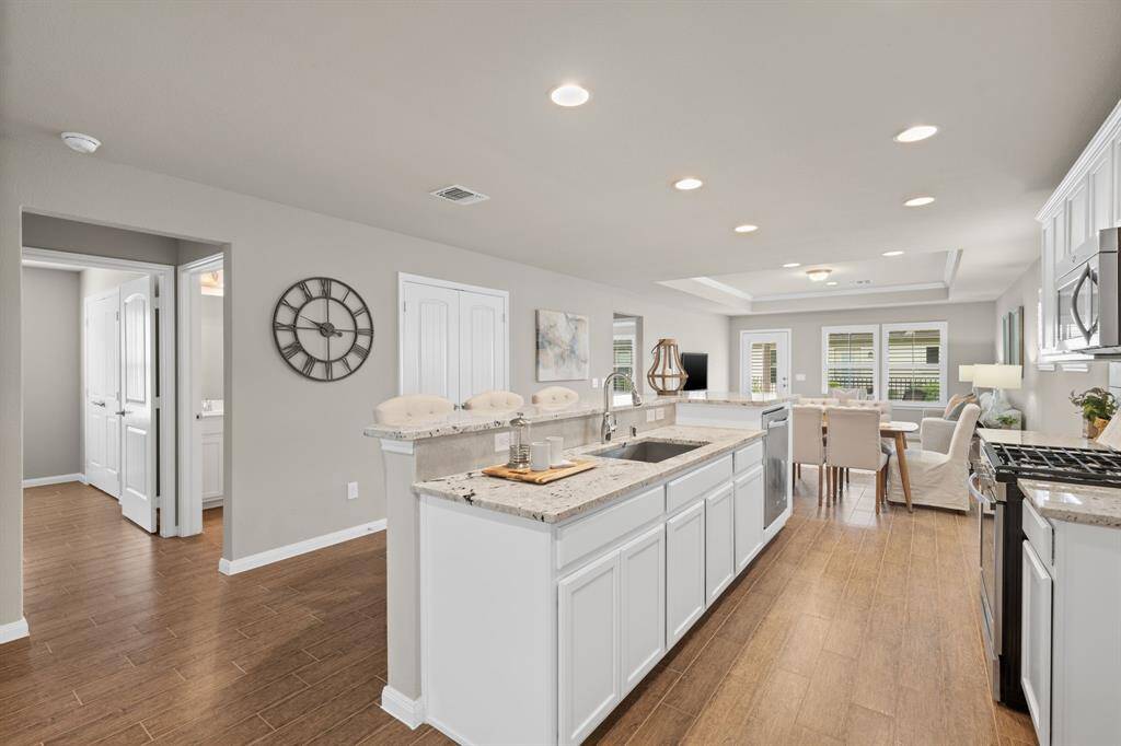 This two-level island offers versatility for dining and prep, with bonus cabinets at the end providing extra storage space.