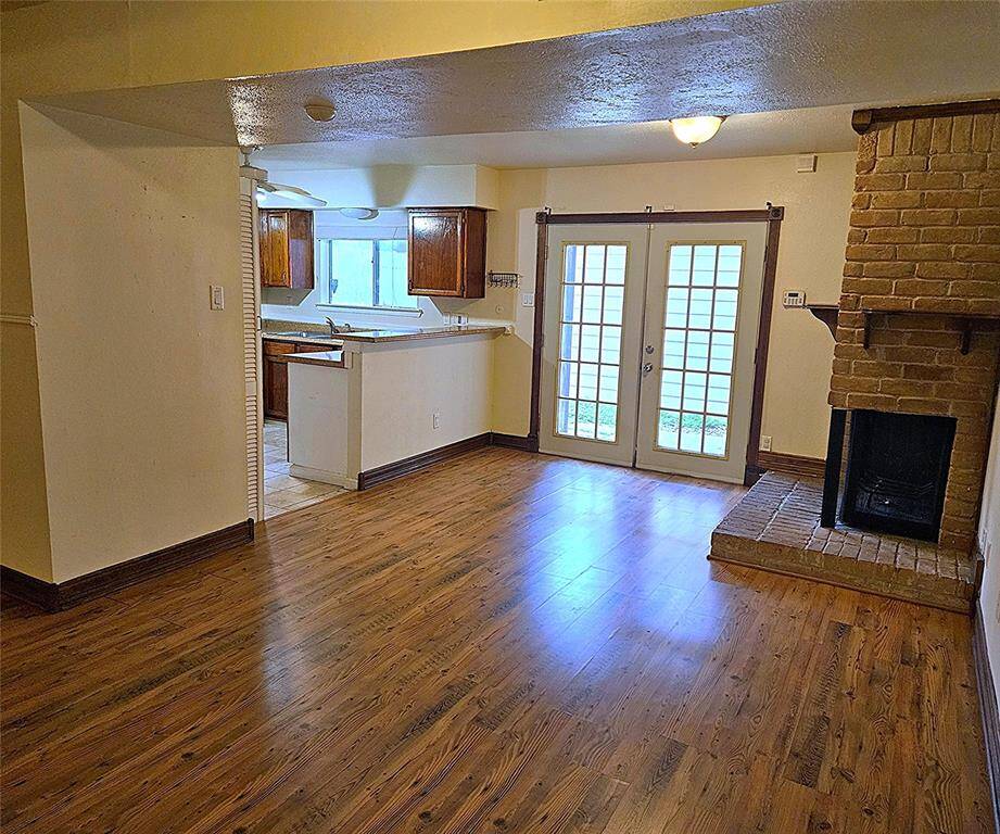 A view from dinette area towards kitchen. Through the double doors is a small courtyard and access to the 2 car garage.