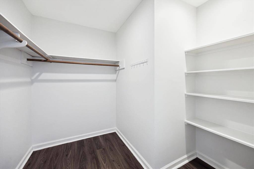 Large walk-in primary closet with built in shelving.