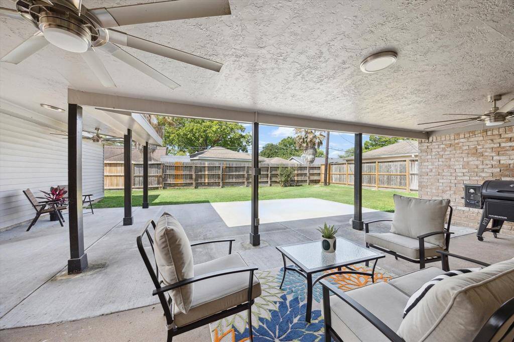 A completely remodeled and expanded covered patio offers plenty of space to relax or entertain—featuring a new concrete slab, recessed lighting, and dual ceiling fans for comfort year-round.