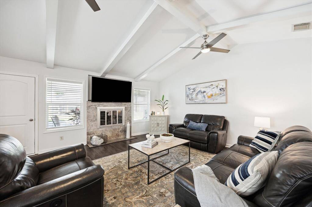 Two large windows frame views of the expansive backyard, filling the room with natural light.