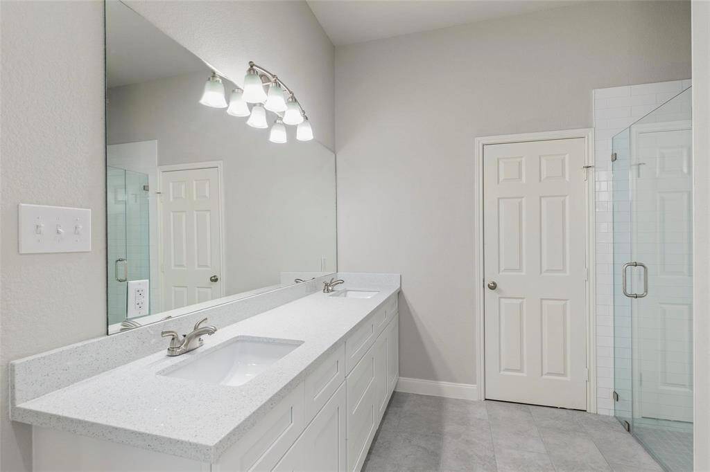 This elegant master bathroom offers a serene retreat with its luxurious Ferdy bathtub, separate shower, and double sinks.