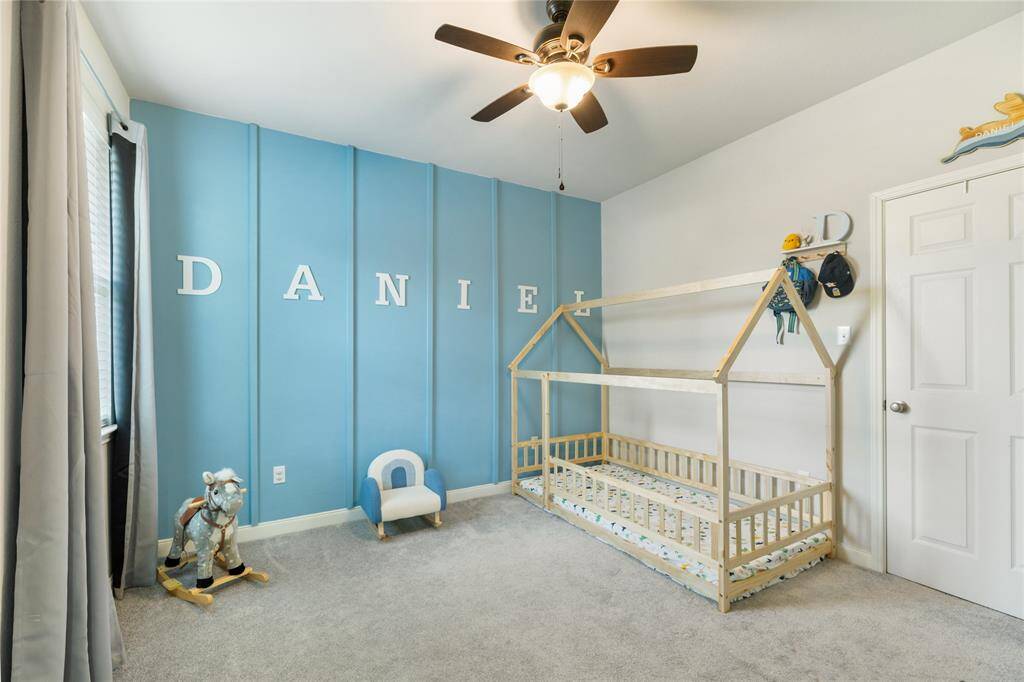 With its fun accent wall, soft carpet, and plenty of natural light, this secondary bedroom offers a bright and cheerful space perfect for play, rest, or creativity. The ceiling fan adds comfort, while the layout easily adapts as your needs change.