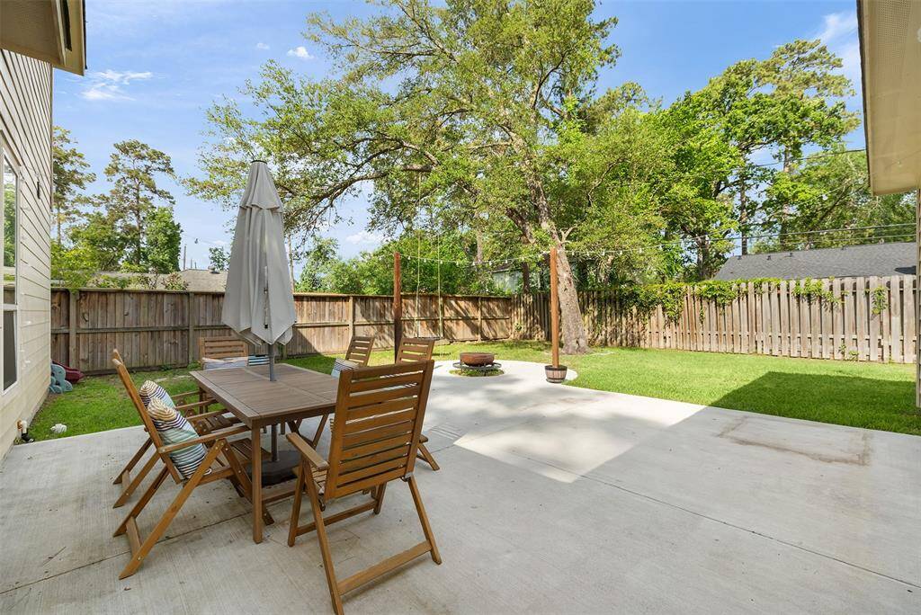 Step into a backyard designed for both relaxation and connection, featuring a spacious patio, lush green lawn, and mature trees that provide shade and charm. The wooden fence offers privacy, making this outdoor space ideal for weekend gatherings, quiet mornings, or playtime in the fresh air.