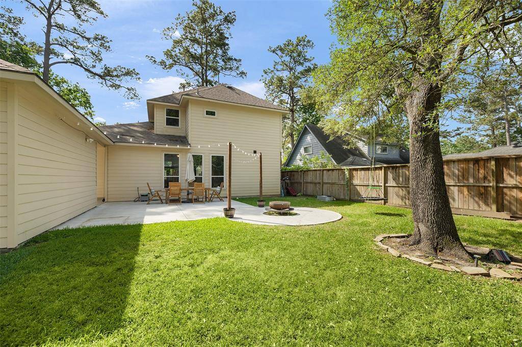 This expansive backyard offers plenty of room to play, relax, and entertain. The large, well-shaded tree provides a perfect focal point, while the concrete patio is ideal for outdoor dining and gatherings. Surrounded by a fenced perimeter, the space offers privacy and endless possibilities for creating your own outdoor oasis.