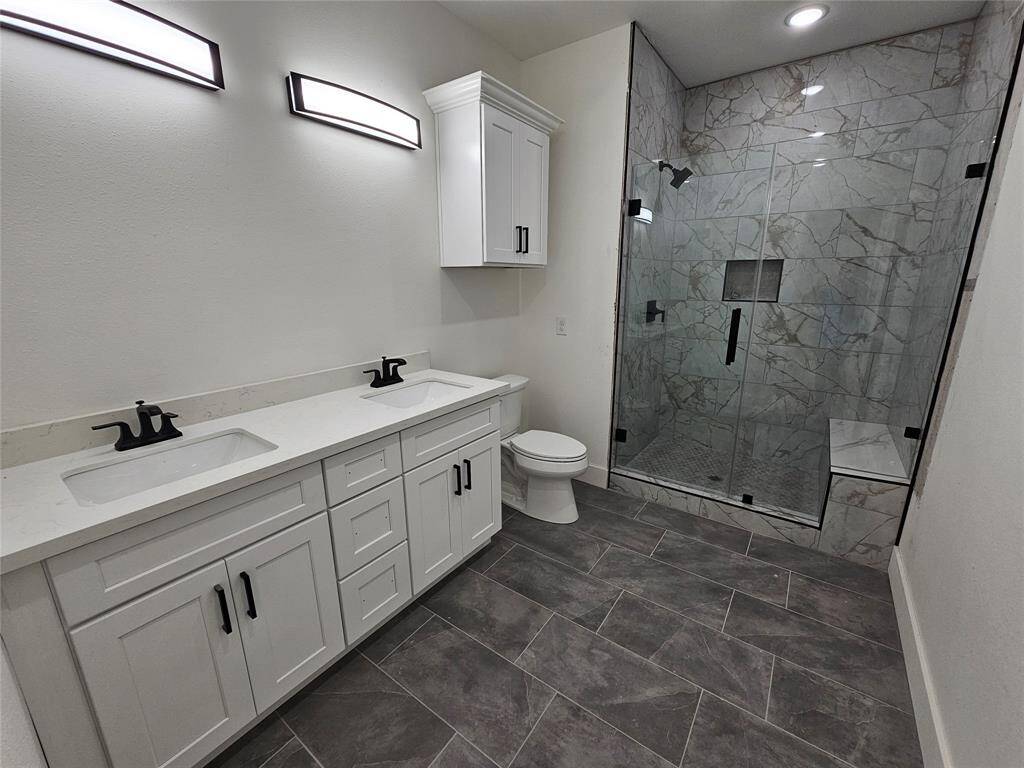 Primary bath with double sinks and elegant walk-in shower.