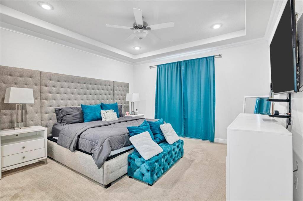 Spacious primary bedroom with crown molding.