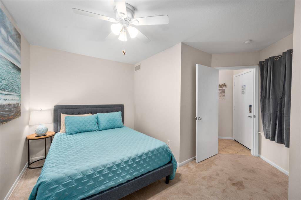Queen bed in the guest bedroom across the hall from the bath.