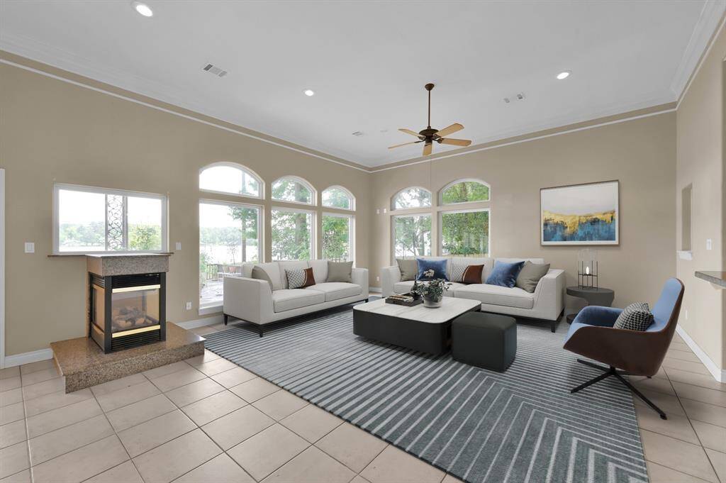 The large living room with oversized windows showcasing Lake Conroe