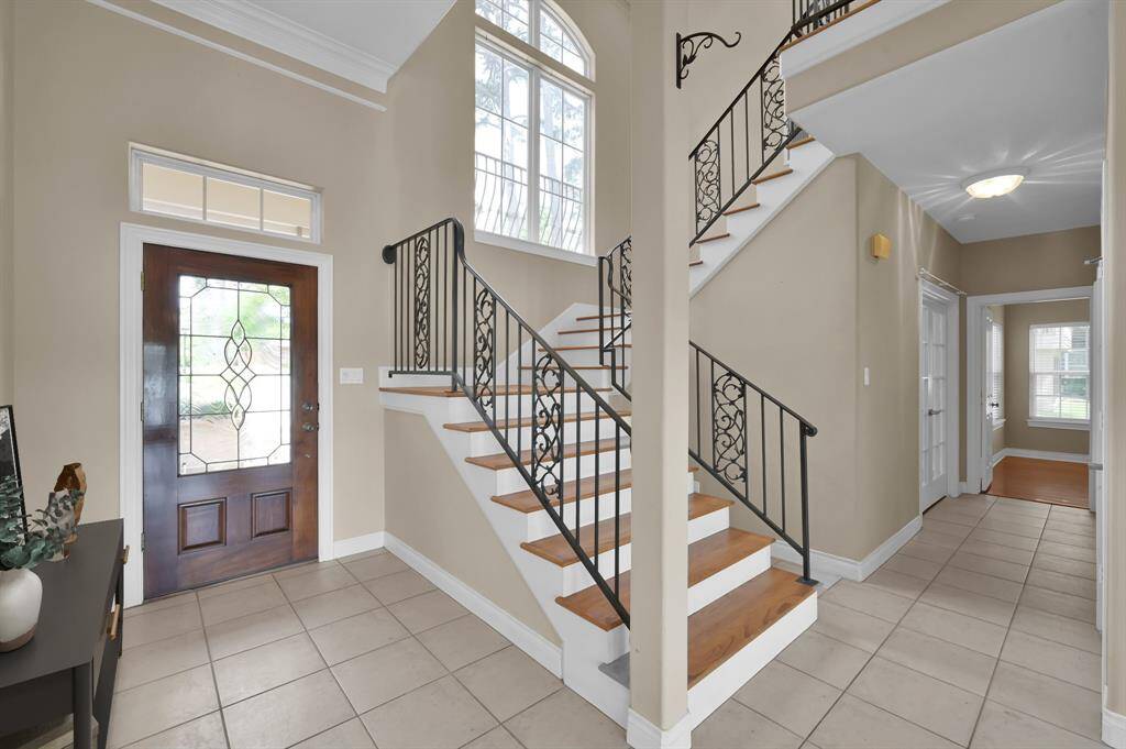 The entry is spacious and showcases the iron staircase