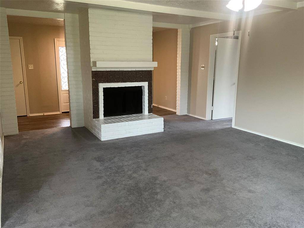 Cozy living room featuring a charming brick fireplace, perfect for relaxing evenings.