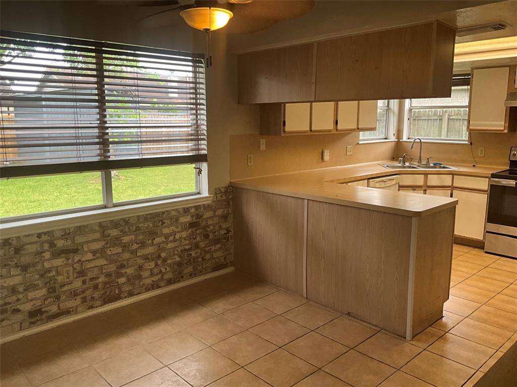 Cozy breakfast nook with ample natural light and a charming brick accent wall, perfect for morning gatherings.