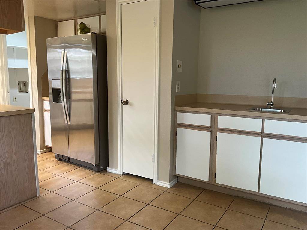 Cozy breakfast nook with convenient access to a wet bar, pantry, and stainless steel refrigerator.