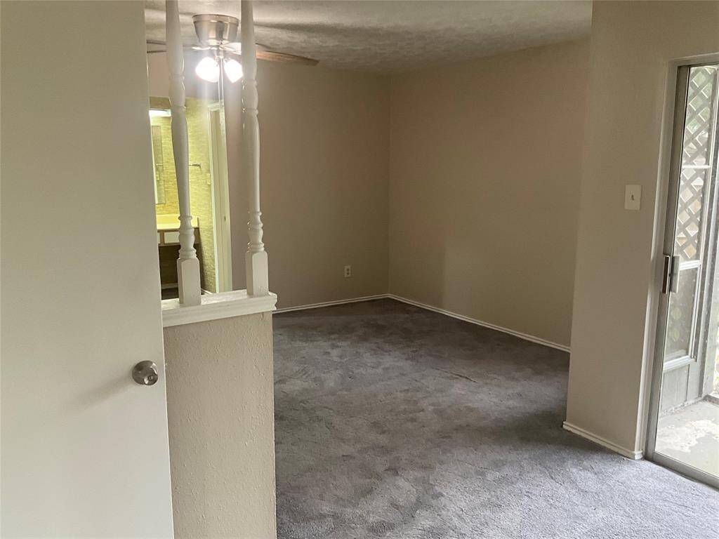 Spacious primary bedroom with cozy carpeting, ample natural light, and easy access to a private outdoor area.