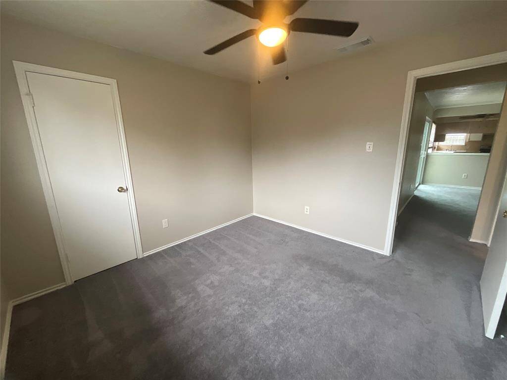 Cozy third bedroom with soft carpeting and ample natural light, perfect for a guest room or home office.