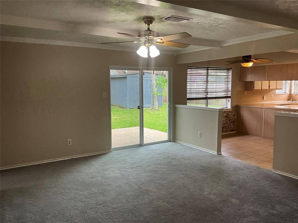 Spacious living room with natural light, seamless flow to the kitchen, and sliding doors leading to a private backyard. Ideal for relaxation and entertaining.