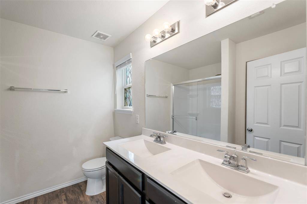 Primary bathroom with double sinks and stone countertop