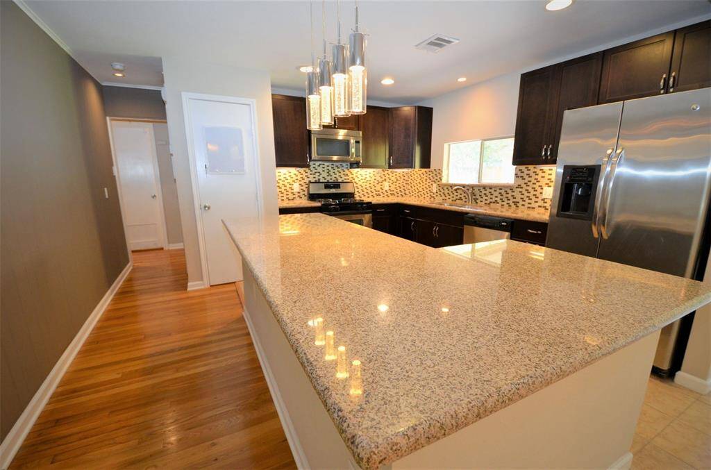 Modern kitchen island with exotic granite and elegant pendant lights.