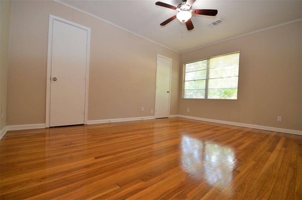 Big master bedroom with white oak hardwood floors, ceiling fan and 2 walk-in closets.