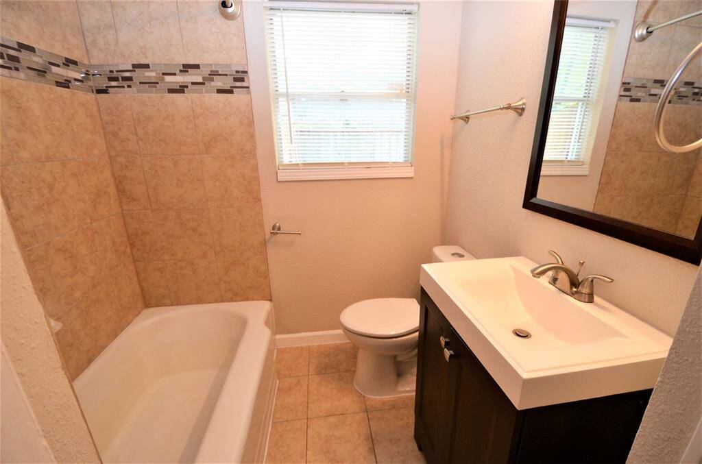 Modern full bathroom with shower tub and chocolate vanity set.