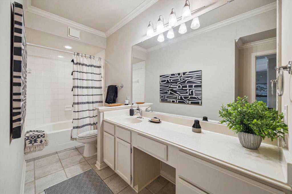 secondary bathroom includes a tub/shower combo, lots of vanity space and storage