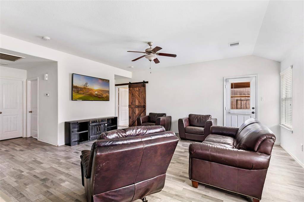 The living room, showing doors to the backyard and the primary suite.