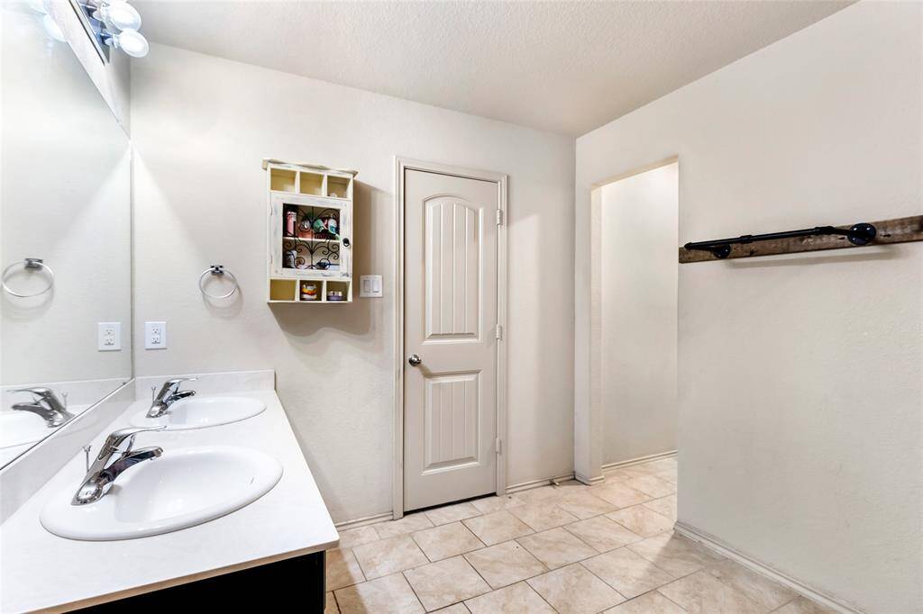 Another view of the primary bathroom, featuring dual sinks
