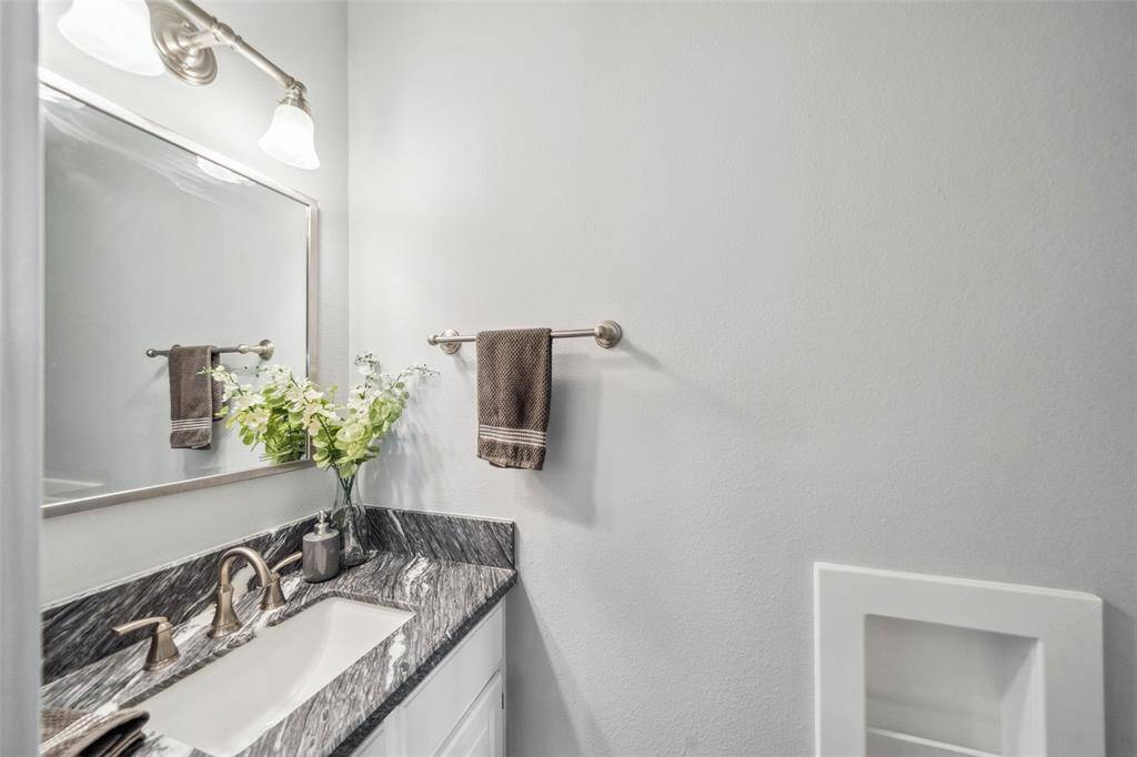 Convenient half bath located on the adjacent hallway which it shares with the laundry room and garage access.