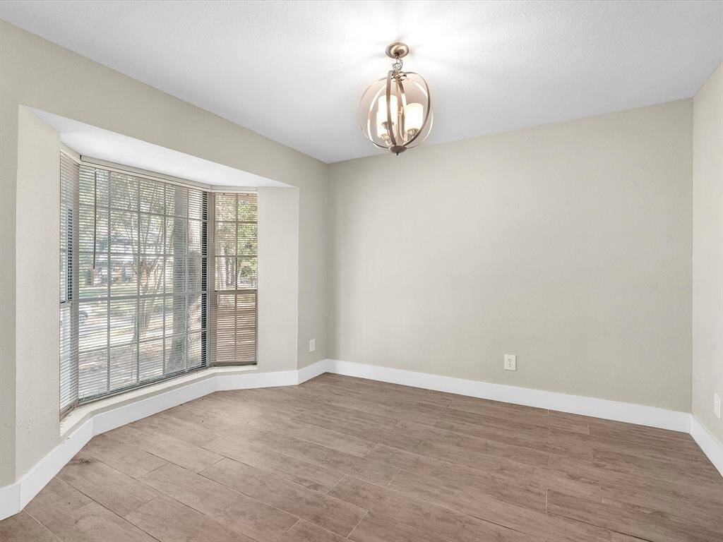 Formal dining room with bay window overlooking front yard.