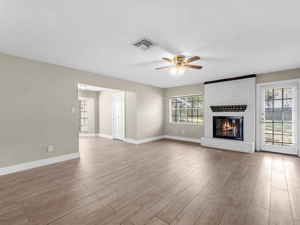 Main open living area featuring a cozy wood-burning fireplace.