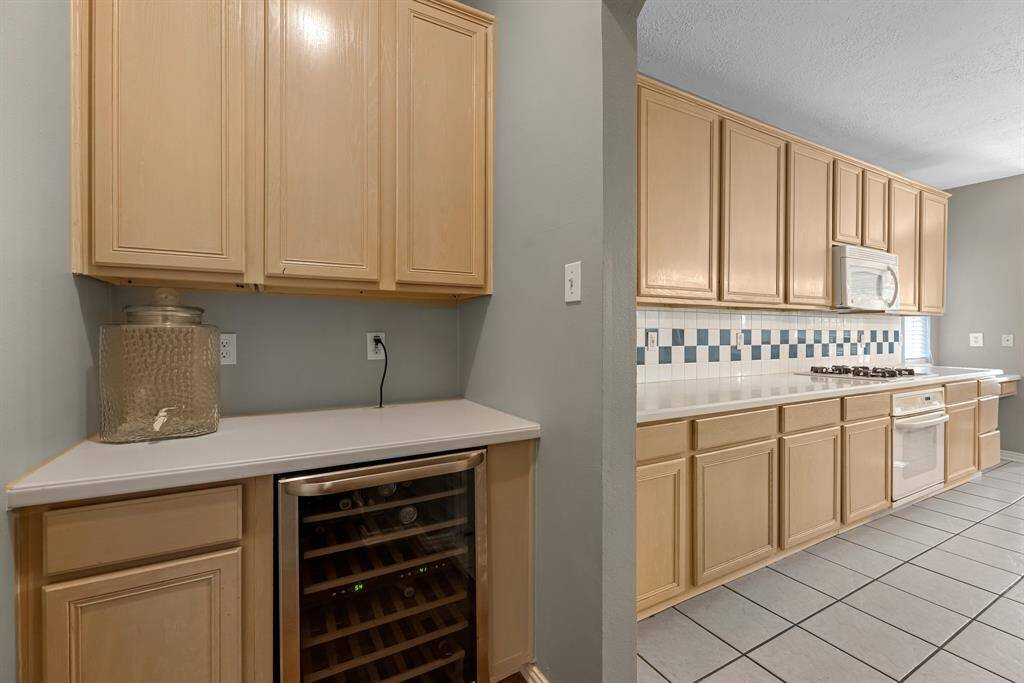 Step into your dream kitchen with ample storage, sleek countertops, and a built-in wine cooler, perfect for culinary adventures and entertaining.