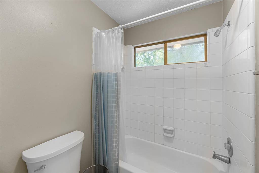 Experience tranquility in this inviting bathroom, featuring a spacious, sunlit tub and modern fixtures.