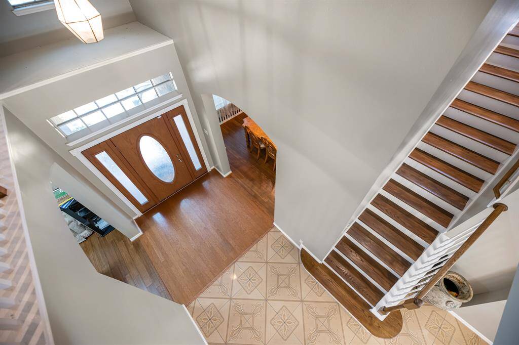 Step into elegance with this inviting entryway, featuring a striking staircase and beautiful flooring. Your dream home begins here.