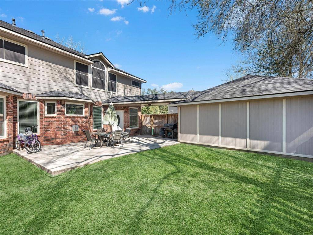 Imagine enjoying sunny afternoons in this inviting backyard, perfect for outdoor dining and relaxation.