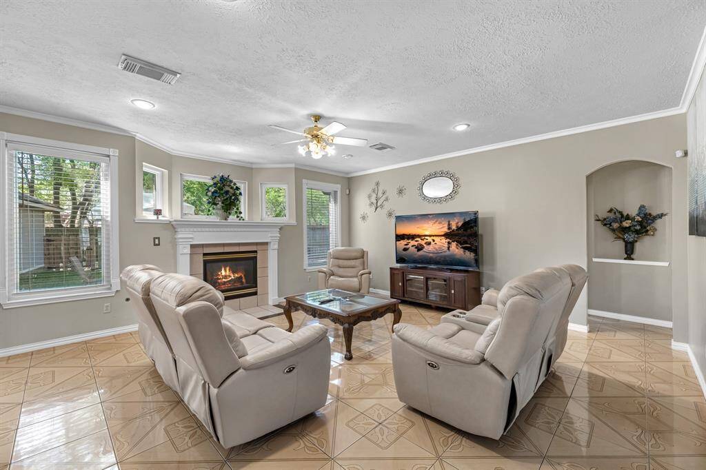 Experience comfort and style in this inviting living room, featuring a cozy fireplace, elegant seating, and abundant natural light. Perfect for relaxation and entertainment.