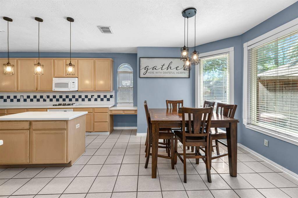 Imagine the warmth of family gatherings in this inviting kitchen, where natural light and modern fixtures create an ideal space for memorable moments.